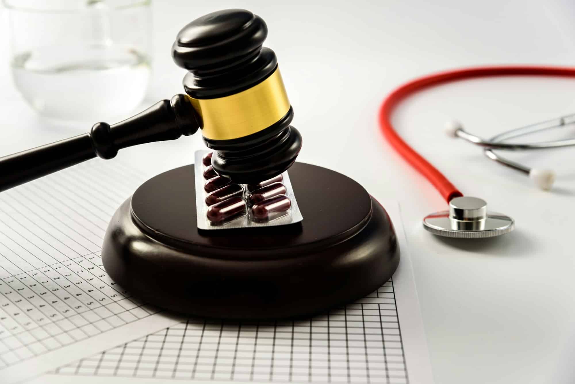 Judge gavel on tablets and pills, sentences a scam from the medical industry.